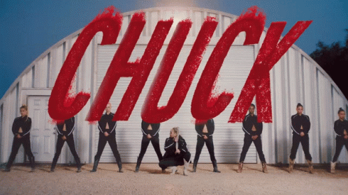Group Of Dancers In Front Of Sign Saying Chuck GIF
