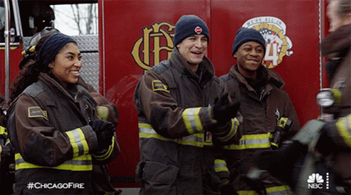 Group Of Firefighters Standing In Front Of Chicago Fire Engine GIF