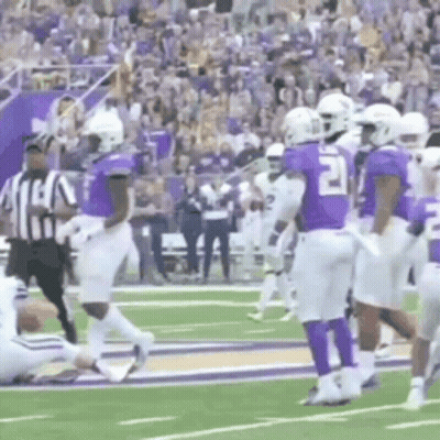 Group of Football Players With Referee on Field