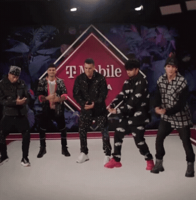 Group Of Men Dancing In Front Of T-Mobile Sign GIF