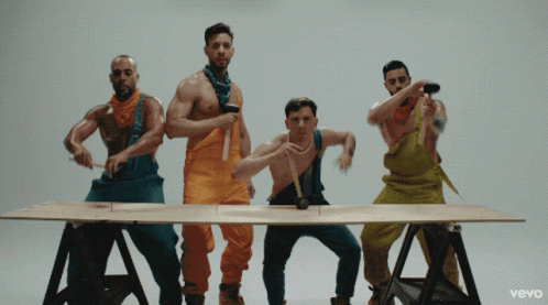 Group Of Men In Overalls Around Table With Vevo GIF