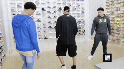 Group Of Men In Shoe Store Looking At Shoes GIF