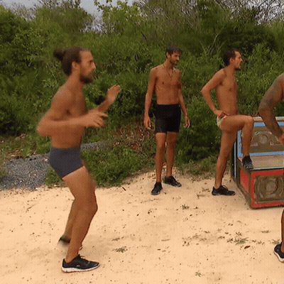 Group Of Men On Sandy Beach One In Shorts GIF