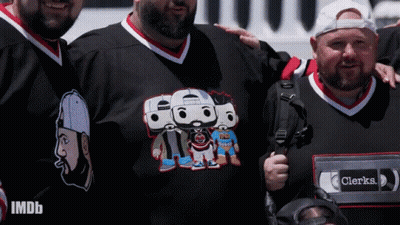 Group Of Men Posing One Wearing Clerks Shirt GIF