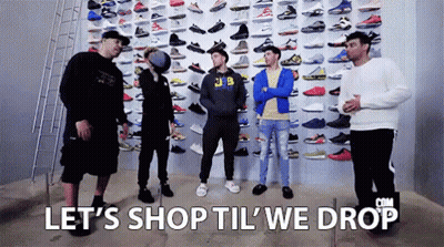 Group Of Men Standing In Front Of Wall Filled With Sneakers GIF