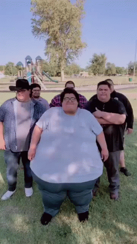 Group Of Men With Very Large Man In Park GIF