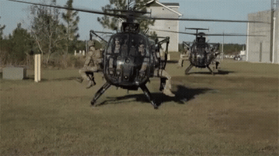 Group Of Military Helicopters In A Field GIF