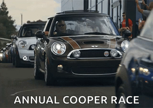 Group Of Mini Cooper Cars Driving Down Street With Words Annual Cooper Race GIF