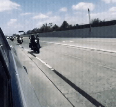 Group Of Motorcycles Riding Down Highway GIF