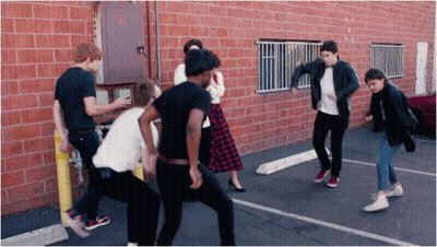 Group Of People Dancing In Front Of Brick Building GIF