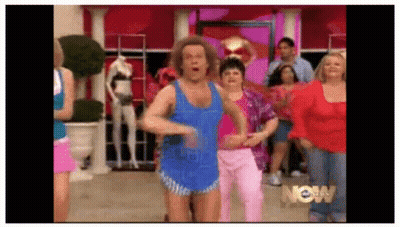 Group Of People Dancing In Front Of Now Sign GIF