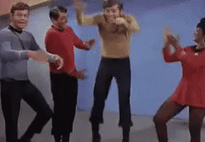 Group Of People Dancing In Room With Blue Wall GIF