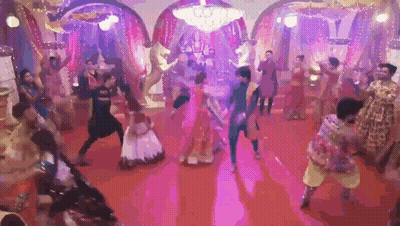 Group Of People Dancing On Red Carpet Under Purple Lights GIF