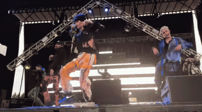 Group Of People Dancing On Stage In Front Of Large Light GIF