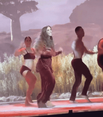 Group Of People Dancing On Stage In Front Of Large Screen GIF