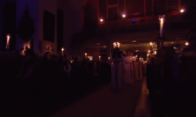 Group Of People Holding Candles In Dark Room GIF