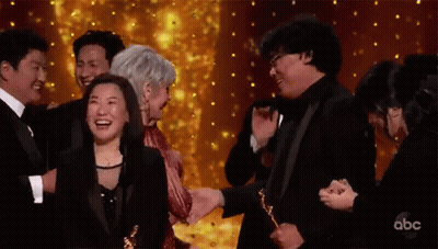 Group Of People Holding Trophies On Stage GIF