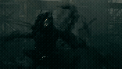 Group Of People In Dark Forest With Light Behind GIF