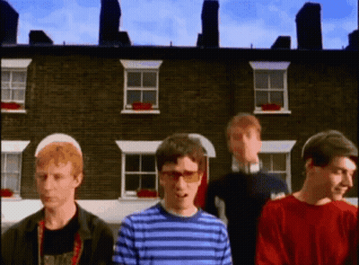 Group Of People In Front Of Brick Building GIF