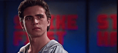 Group Of People In Front Of Wall Saying Strike First Strike Me GIF