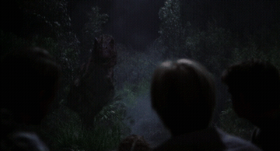 Group Of People Looking At Dinosaur In Dark Forest GIF