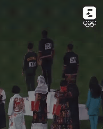 Group Of People On Podium With Numbers On Backs GIF