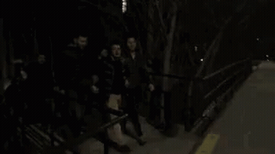 Group Of People On Sidewalk At Night GIF