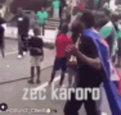 Group Of People On Street With Zec Kaoro Text GIF
