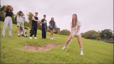 Group Of People Playing Golf On Grassy Hill GIF
