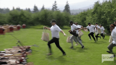 Group Of People Running In Field With Bravo Logo GIF
