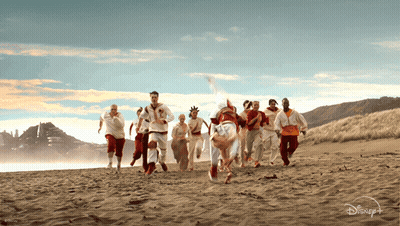 Group Of People Running On Beach With Disney Logo GIF