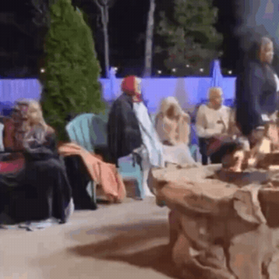 Group Of People Sitting Around Fire Pit At Night GIF