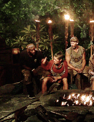 Group Of People Sitting Around Fire Pit At Night GIF