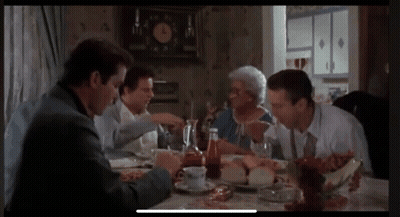 Group Of People Sitting Around Table With Clock GIF