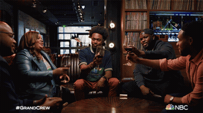 Group Of People Sitting Around Table With NBC Logo GIF