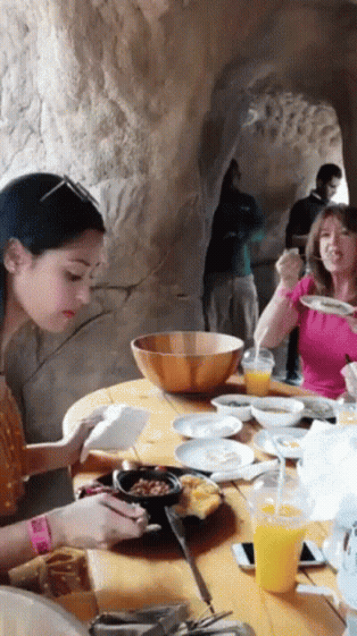 Group Of People Sitting At Table With Food And Drinks GIF