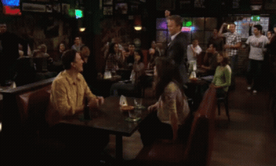Group Of People Sitting At Tables In A Bar GIF