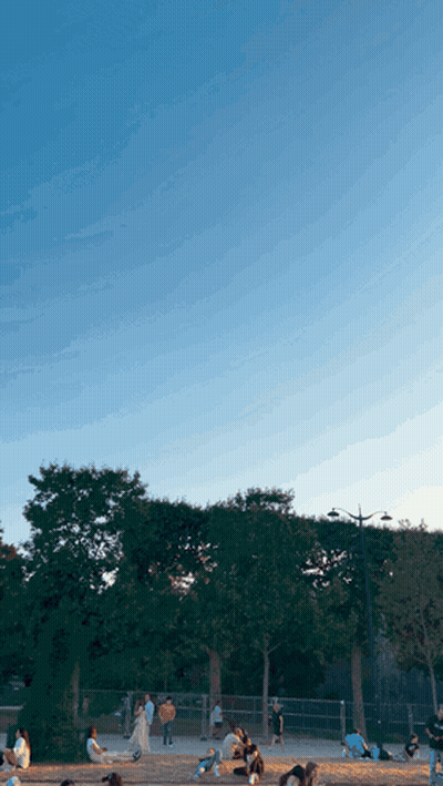 Group Of People Sitting In Park With Blue Sky GIF