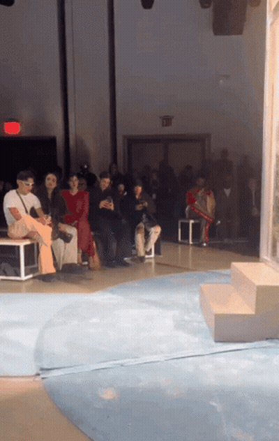 Group Of People Sitting In Room With Red Exit Sign GIF