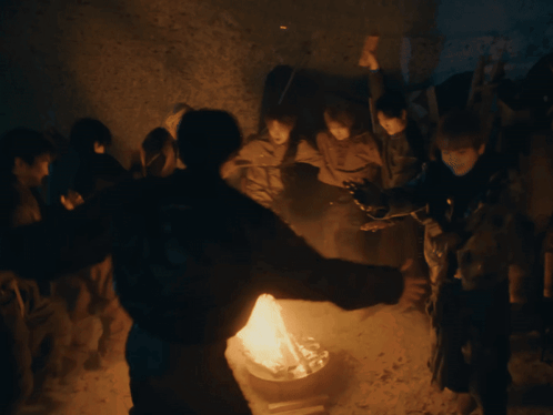 Group Of People Standing Around Fire GIF