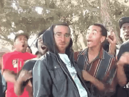 Group Of People Standing Around Man In Hoodie GIF