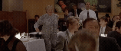 Group Of People Standing Around Table Saying Help Is On The Way GIF
