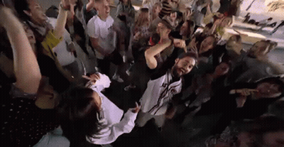 Group of People Standing Around Woman in Crowd