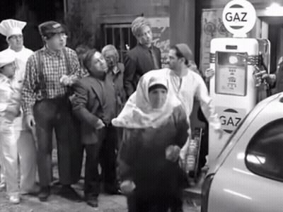 Group Of People Standing At Gas Pump GIF