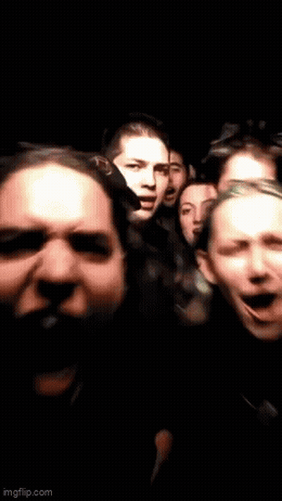 Group Of People Standing In Dark Room With Mouths Open GIF