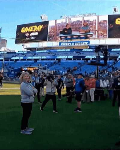 Group Of People Standing In Front Of Gameday Stadium GIF