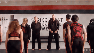 Group Of People Standing In Front Of Strike First Strike Me Wall GIF