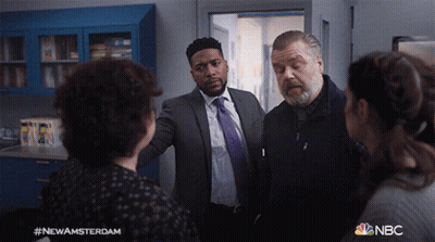 Group Of People Standing In Room With NBC Logo GIF