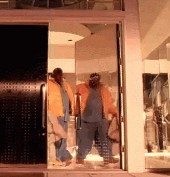 Group Of People Standing In Room With Open Door GIF