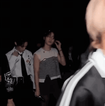 Group Of People Standing In The Dark GIF